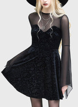 Load image into Gallery viewer, Model wearing a black dress with sheer sleeves and a black hat on a white background