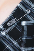 Load image into Gallery viewer, Close-up of a black and blue plaid fabric with a metal pin labeled ''IGIRL'