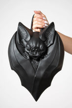 Load image into Gallery viewer, Black bat-shaped handbag held by a person against a white background