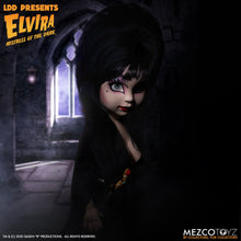 Load image into Gallery viewer, front side view of Elvira Living Dead Doll, with iconic black dress and batty, teased hair, and comes with a dagger that she can store in her waist belt. Stands 10” tall and features 5 points of articulation. Packaged in window box for display.