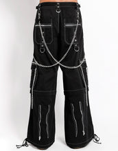 Load image into Gallery viewer, back view of Black baggy Tripp pants with white stitching. Pants have front rivet details, side pocket hanging chain details, removable attached chains, back zipper details and more. Pant legs can also zip off into shorts.