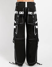 Load image into Gallery viewer, back of Black and white pants feature white stitching, removable straps, adjustable ankles, D-rings, clasps, and deep pockets.