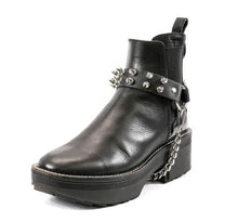 Load image into Gallery viewer, black ankle boot displaying black leather boot strap with two rows of silver tree spikes, single silver o ring and silver hanging chain