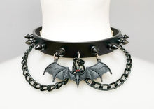 Load image into Gallery viewer, Black leather collar with 1/2" black spikes, black hanging chain, and black bat with red eyes hanging from the front center.