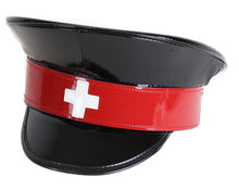 Load image into Gallery viewer, Black shiny patent vegan leather police hat. Front of hat has red strap across the front, with a white cross in the center of the red strap.