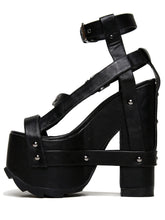 Load image into Gallery viewer, outer view of black vegan leather strappy platform sandal with 6.5" heel. Sandal has gunmetal hardware, adjustable ankle strap and adjustable side strap. Bottom of front platform has a fanned grip for better stability.