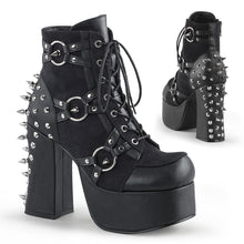 Load image into Gallery viewer, right and backside view of black vegan leather with suede panels 4.5 inch heel ankle boot with three O ring designs with spike in middle on each side of boot, tree spikes and s tuds on the back and 7 eyelet lace-up front