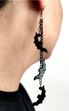 Load image into Gallery viewer, Three silver zinc alloy chains hanging from hook stud. Chains hang at different lengths with an acrylic black see-through bat hanging from each chain.