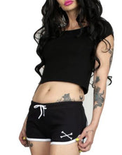 Load image into Gallery viewer, Black shorts with whitetrim and white skeleton hands design on both buttcheeks, white drawstring and white cross bones on front left
