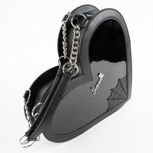Load image into Gallery viewer, side view of heart shaped glossy black bag with a stitched spiderweb design at the bottom, chain link hardware and faux leather straps.
