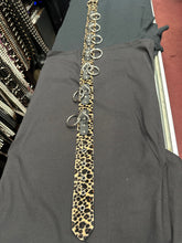 Load image into Gallery viewer, Leopard print tie with metal rings on a gray garment in a store setting
