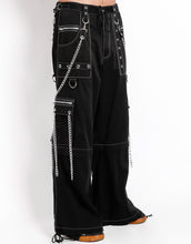Load image into Gallery viewer, side view of Black baggy Tripp pants with white stitching. Pants have front rivet details, side pocket hanging chain details, removable attached chains, back zipper details and more. Pant legs can also zip off into shorts.
