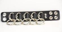 Load image into Gallery viewer, black leather bracelet with five silver d rings with five hanging silver o rings attached. shows snap closure
