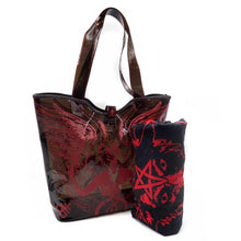 Load image into Gallery viewer, See-through black PVC beach tote. Bag has red Baphomet print on it. Bag has a double handle and snap closure. Towel in picture not included.
