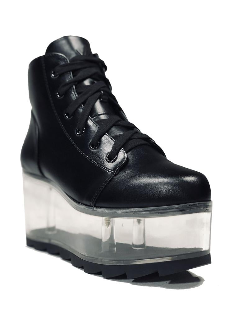 outer view of black vegan leather platform shoe with clear plastic platform. Shoe looks like a sneaker, but is super tall! Clear plastic bottom has a Velcro foot bed opening, to insert toys, candy or fun stuff into the clear bottom of the shoe.