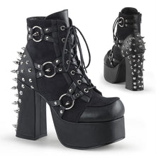 Load image into Gallery viewer, right and backside view of black vegan leather with suede panels 4.5 inch heel ankle boot with three O ring designs with spike in middle on each side of boot, tree spikes and s tuds on the back and 7 eyelet lace-up front 
