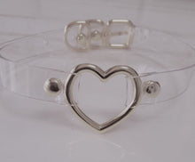 Load image into Gallery viewer, front view of Clear pvc choker with Metal heart at front center and Adjustable buckle closure on back

