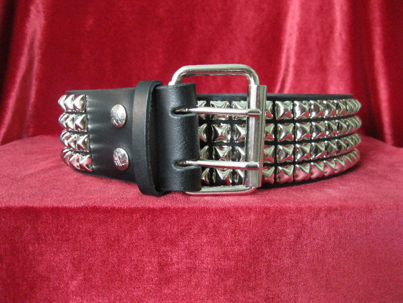 wide width black leather belt with four rows of silver pyramid studs. shows silver adjustable buckle