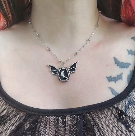 Silver colored zinc alloy bat wing necklace with silver crescent moon in center.
